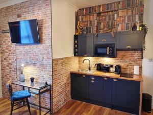 沃特福德Ricky Road Guest House - "Wizard Studio Room" Available to Book Now的厨房设有水槽和砖墙