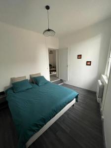 ToucyMaison face à l'eglise的一间卧室配有一张带蓝色枕头的大床