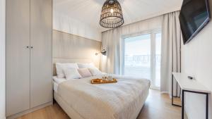 科沃布热格Apartament Lux Tukan B002, Polanki Aqua - Holiday City的一间白色的卧室,配有一张带托盘的床