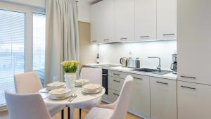 科沃布热格Apartament Lux Tukan B002, Polanki Aqua - Holiday City的白色的厨房配有白色的桌子和椅子