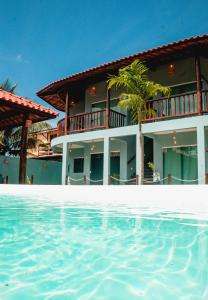 佩德拉斯港Vila Las Hermanas的一座带游泳池的度假村,位于一座建筑前
