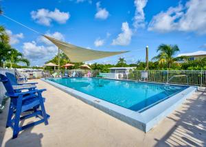 马拉松Aqua Lodges at Coconut Cay Rv and Marina的蓝色椅子旁边的游泳池