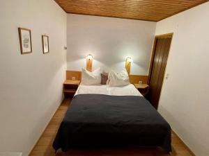 巴特霍夫加施泰因安格度假酒店的一间卧室配有一张大床、两张桌子和两盏灯。