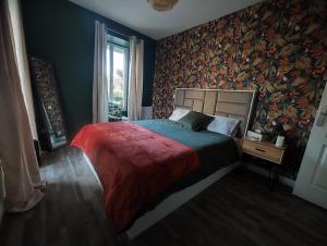 Chaumes-en-BrieJacuzzi privatif - Suite Amazonie - 1 ou 2 chambres的一间卧室设有一张大床和色彩缤纷的墙壁