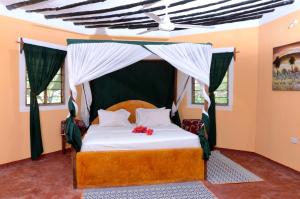 乌罗阿考雷沙滩小屋的一间卧室配有一张带天蓬的床