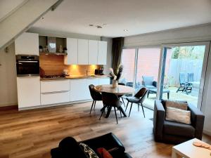 佐特兰德Bosweg 9a, Comfortabele vakantiewoning, Centrum Zoutelande的厨房以及带桌椅的起居室。