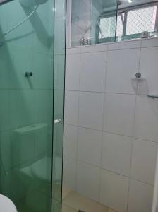 圣维森特岛Lindo apto vista lateral do mar Itararé São Vicente的浴室里设有玻璃门淋浴