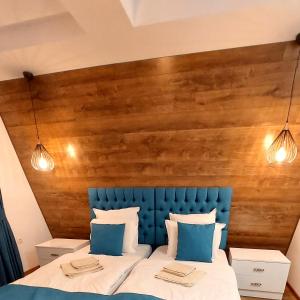 拉兹洛格Къща за гости Радост Guest House Radost的一张带蓝色床头板和两盏灯的床