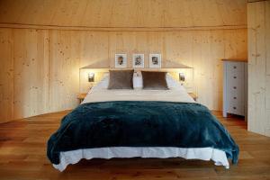 格拉斯哥Luxury romantic Roundhouse and hot tub for two的卧室配有一张木墙内的大床