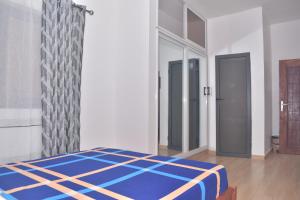 洛美RÉSIDENCE BELLEVUE SITO AIPORT- Lomé的一间位于客房内的蓝色床卧室