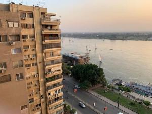 开罗Schöne Wohnung mit Blick auf Nil und Pyramiden的一条河旁的一座高楼,里面装有船只
