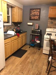 匹兹堡Cuddys Place的厨房配有木制橱柜和白色冰箱。