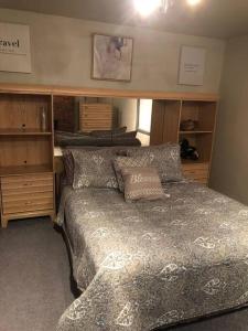 匹兹堡Cuddys Place的一间卧室配有一张床和一些木橱柜。