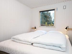伦德Holiday home Rønde XXIV的白色客房的两张床,设有窗户