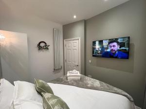 普雷斯顿Winckley Square Residences的卧室配有一张床铺,墙上配有电视