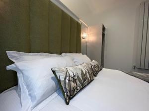 普雷斯顿Winckley Square Residences的一张带白色枕头和绿色床头板的床