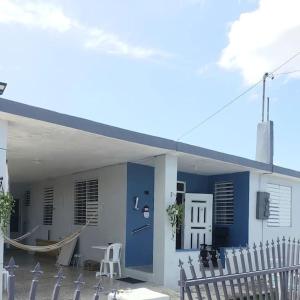 阿瓜达Casa Amalia Beach House的蓝色的建筑,前方设有门廊和吊床