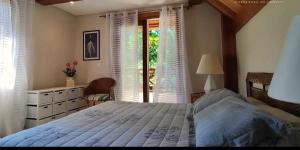 瓜鲁雅Casa elegante em condomínio的一间卧室设有一张大床和一个窗户。