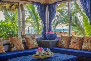 埃斯孔迪多港Sunset Beachside House With Appartent的配有蓝色沙发并享有海滩景色的客房