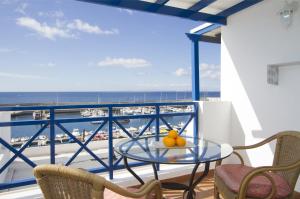 卡门港海港之光公寓的一个带桌椅的海景阳台
