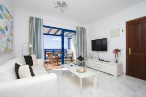 卡门港海港之光公寓的客厅配有白色沙发和电视