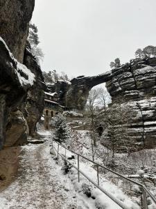 亚诺夫Pension U Václava的石桥旁的一条雪覆盖的小径