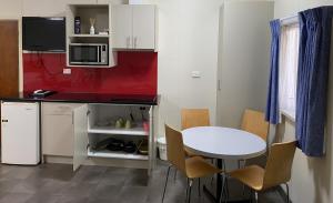 伊丘卡爱酷卡汽车旅馆的一间小厨房,配有白色的桌子和红色的墙壁