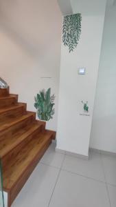 务边Gopeng Serumah Holiday House的墙上有楼梯和植物的房间