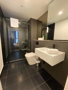 堪培拉2 Bed 2 Bath Luxury Apartment in Braddon Canberra - Free heated pool, gym, parking的一间带水槽和卫生间的浴室