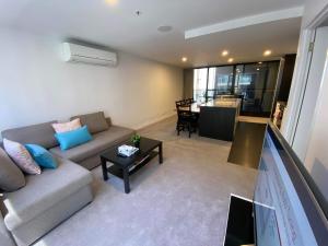 堪培拉2 Bed 2 Bath Luxury Apartment in Braddon Canberra - Free heated pool, gym, parking的客厅配有沙发和桌子