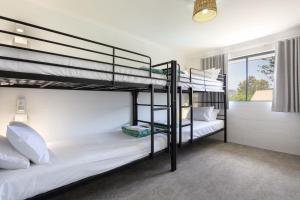 穆卢拉巴Abode Mooloolaba, Backpackers & Motel rooms的带窗户的客房内的两张双层床