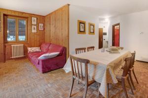 博尔米奥Casa Rossella的客厅配有桌子和红色沙发