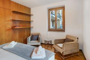 博尔米奥Casa Rossella的一间卧室配有两把椅子、一张床和窗户