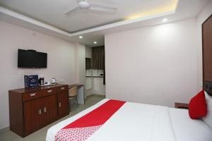 BankipurKamat Inn的卧室配有一张床,墙上配有电视。