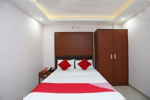 BankipurKamat Inn的一间卧室配有一张带红色枕头的大床