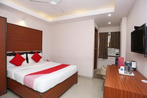 BankipurKamat Inn的一间卧室配有一张带红色枕头的床和一张书桌