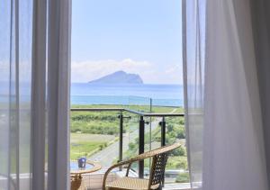 头城兰阳乌石港海景酒店的阳台配有两把椅子,享有海景。
