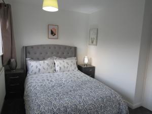 诺丁汉Remarkable and perfect 3 Bed House in Nottingham的一间卧室配有一张带蓝色和白色棉被的床
