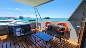 兰格班Kraalbaai Lifestyle House Boats的船上的甲板上配有桌椅