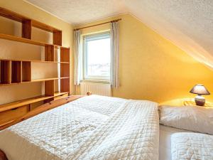 格洛韦Doppelhaushälfte in Glowe - D 120.008的卧室配有白色的床和窗户。