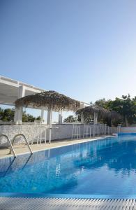 佩里萨Aspro Phos Santorini Hotel的一个带椅子和遮阳伞的大型蓝色游泳池