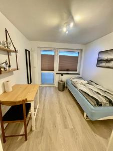 奥胡斯City Aarhus的一间卧室配有一张床、一张书桌和两个窗户。