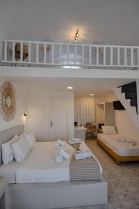 佩里萨Aspro Phos Santorini Hotel的客厅设有一张大床和一个楼梯