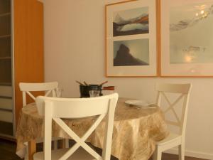 采尔马特采尔马特精品酒店的餐桌、白色椅子和桌子