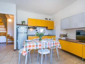 杜纳维德Apartment Robinia-Pinetine-4 by Interhome的厨房配有桌椅和黄色橱柜