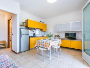 杜纳维德Apartment Robinia-Pinetine-4 by Interhome的厨房配有黄色橱柜和桌椅