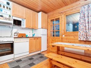 NissiHoliday Home Hillakumpu by Interhome的厨房配有木制橱柜和木桌。