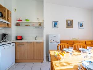 朋泰雷克Apartment Jardins de Pontaillac-1 by Interhome的厨房配有木桌,上面放着一碗水果