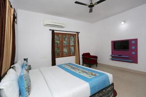 布巴内什瓦尔OYO Maa Banadurga Inn的一间卧室配有一张床和一台平面电视