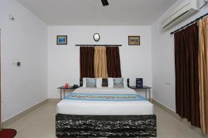 布巴内什瓦尔OYO Maa Banadurga Inn的一间卧室配有一张带棕色窗帘的大床